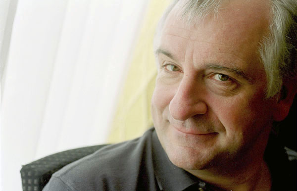Douglas Adams, smiling, leaning towards the camera